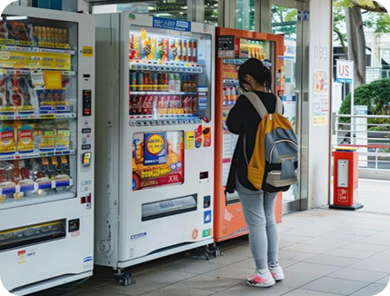 A person using vending machines outdoors.