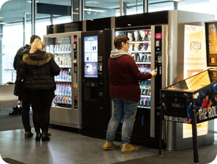 A person using vending machines indoors.